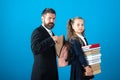 Little school girl hold big stack school textbook notebook books. Father teacher helping to pupil, preparing backpack