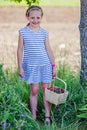 Little school girl holding basket full of strawberries at self picking farm. Royalty Free Stock Photo