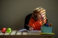 Little school kid boy doing homework at home. Child thinking, kids dream. Royalty Free Stock Photo