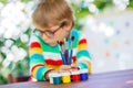 Little school kid boy with glasses holding lots of brushes and c Royalty Free Stock Photo