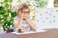 Little school kid boy with glasses holding wax crayons Royalty Free Stock Photo