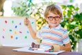 Little school kid boy with glasses holding wax crayons Royalty Free Stock Photo