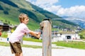 Little school kid boy playing with water pump on hot summer day Royalty Free Stock Photo