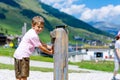 Little school kid boy playing with water pump on hot summer day Royalty Free Stock Photo