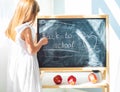 Little schoolage girl drawing on the blackboard