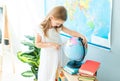 Little schoolage girl look pointing on the globe Royalty Free Stock Photo