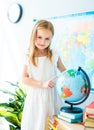 Little schoolage girl look pointing on the globe