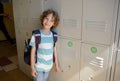 Little schoolboy standing near lockers in school hallway. Royalty Free Stock Photo