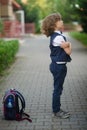 Little schoolboy stands in the school yard with an angry expression on his face . Royalty Free Stock Photo