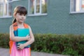 Little schoolgirl with backpack holding notebooks