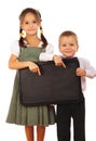 Little schoolgirl and boy with empty chalkboard