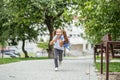 The little schoolgirl is running with a backpack and laughing. The concept of school, study, education, friendship, childhood Royalty Free Stock Photo