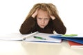 Little schoolgirl sad and tired looking depressed suffering stress overwhelmed by load of homework Royalty Free Stock Photo