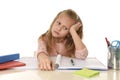 Little schoolgirl sad and tired looking depressed suffering stress overwhelmed by load of homework Royalty Free Stock Photo