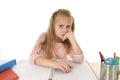 Little schoolgirl sad and tired looking depressed suffering stress overwhelmed by load of homework Royalty Free Stock Photo