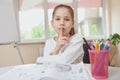 Little schoolgirl shushing to the camera with her finger to her mouth