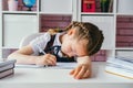 A little schoolgirl sleeps at her desk during a lesson Royalty Free Stock Photo