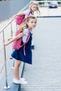 little schoolgirls with pink backpacks playing