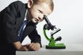 Little scientist looking in microscope.little boy in tie.stylish child.Schoolboy Royalty Free Stock Photo