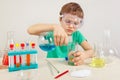 Little scientist in safety goggles doing chemical experiments in laboratory Royalty Free Stock Photo