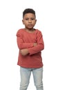 Little serious dark skinned African boy with arms acrossing, isolated