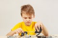 Little serious engineer plays with mechanical kit at table