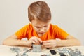 Little serious engineer plays with mechanical starter kit at table