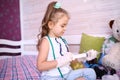 little serious girl in a medicalg gloves with stethoscope at home playing doctor Royalty Free Stock Photo