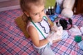 Little serious girl in a medicalg gloves with stethoscope at home playing doctor Royalty Free Stock Photo