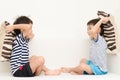 Little sibling boy playing pillow fighting on sofa