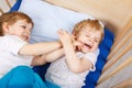 Little sibling boys having fun in bed at home Royalty Free Stock Photo