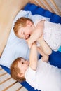 Little sibling boys having fun in bed at home Royalty Free Stock Photo