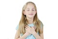 Little sincere adorable girl closed eyes holding hands on chest feeling gratitude pose, arms on heart gesture of love appreciatio