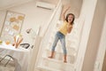 Little singer. Cute and happy caucasian girl wearing headphones standing on stairs and listening music, she is singing Royalty Free Stock Photo