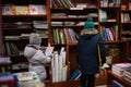 Little sister with brother in jacket reaching a book from bookshelf at the library. Learning and education of european kids Royalty Free Stock Photo
