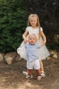 Little sister and brother walkind outside. Beautiful children in summer time. Blond hair chidren