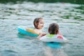 Little sisters having fun swimming in a lake Royalty Free Stock Photo