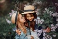 Little sisters outdoor portrait near lilac tree