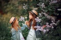 Little sisters outdoor portrait near lilac tree