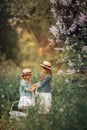 Little sisters outdoor portrait near lilac tree