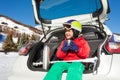 Little skier sitting in car boot and drinking tea Royalty Free Stock Photo
