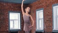 A little skinny ballerina girl training movements in the studio