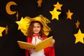 Little sky watcher studying stars with big book