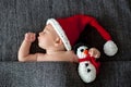 Little sleeping newborn baby boy, wearing Santa hat and holding Royalty Free Stock Photo