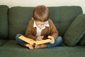 Little smart boy reads a big book