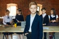 Little smart boy in stylish suit standing with a hand on the pocket