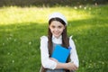 Little smart girl with book outdoors sunny day, sophisticated schoolgirl concept Royalty Free Stock Photo