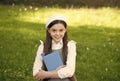 Little smart girl with book outdoors sunny day, sophisticated schoolgirl concept Royalty Free Stock Photo