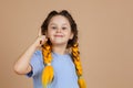 Little smart girl with kanekalon braids of yellow color showing finger having aha moment because of great idea appearing Royalty Free Stock Photo