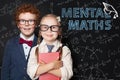 Little smart kids boy and girl student on blackboard background with science and maths formulas. Mental maths concept Royalty Free Stock Photo